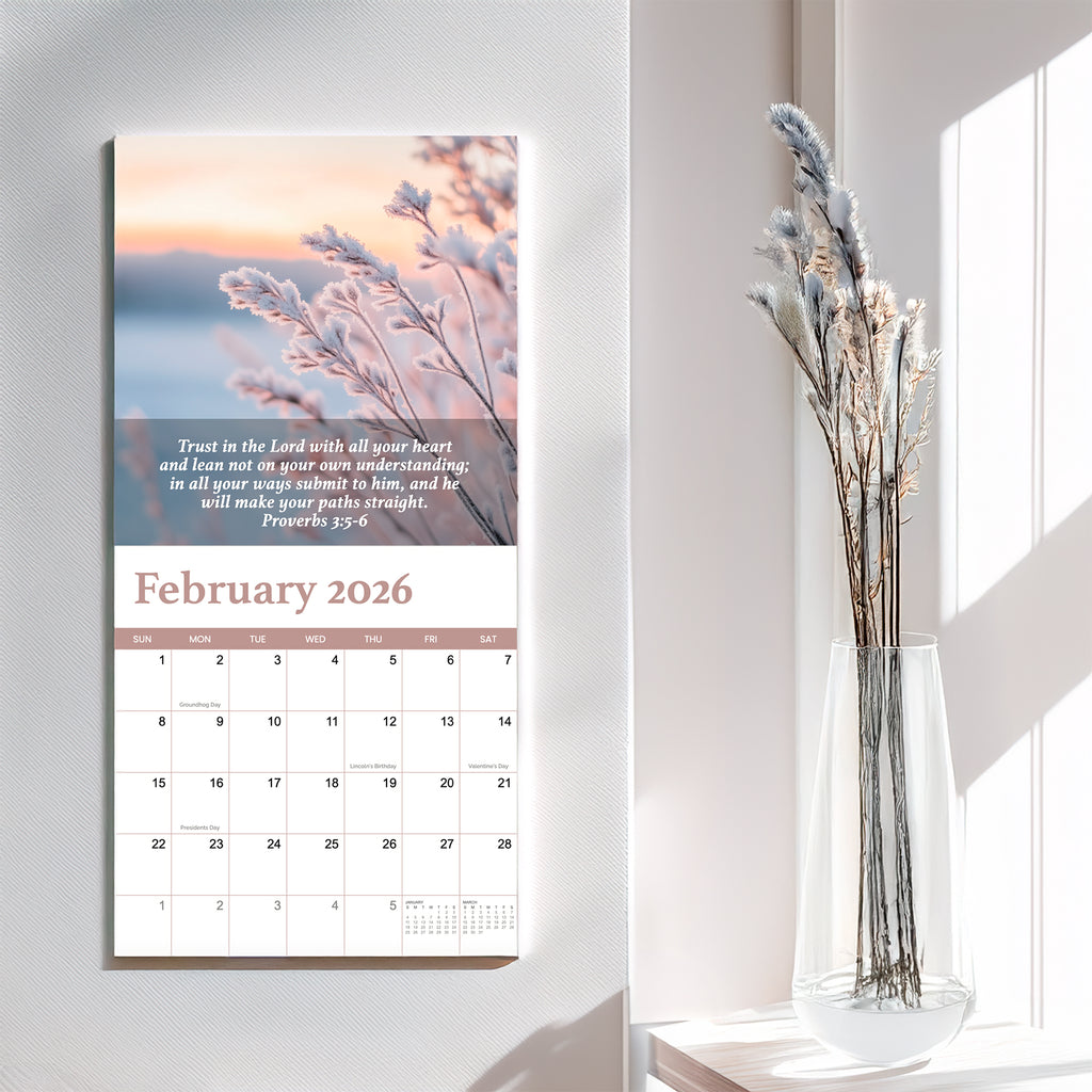 The 2026 Religious Wall Calendar by HannahFaithstore displays Proverbs 3:5-6 for February, featuring frosted plants and dried flowers in a clear vase on a white table—a thoughtful faith-based gift.
