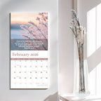 The 2026 Religious Wall Calendar by HannahFaithstore displays Proverbs 3:5-6 for February, featuring frosted plants and dried flowers in a clear vase on a white table—a thoughtful faith-based gift.
