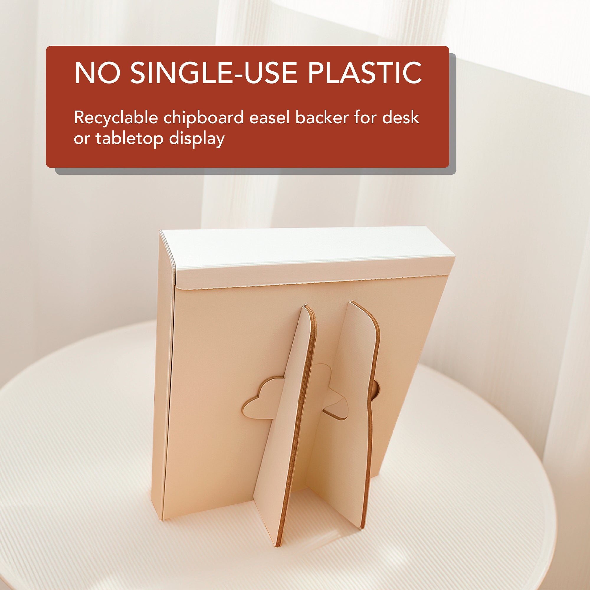 A recyclable chipboard easel backer displays the HannahFaithstore 2026 A Verse A Day Calendar, standing on a surface with a “NO SINGLE-USE PLASTIC” sign above and white curtains in the background.