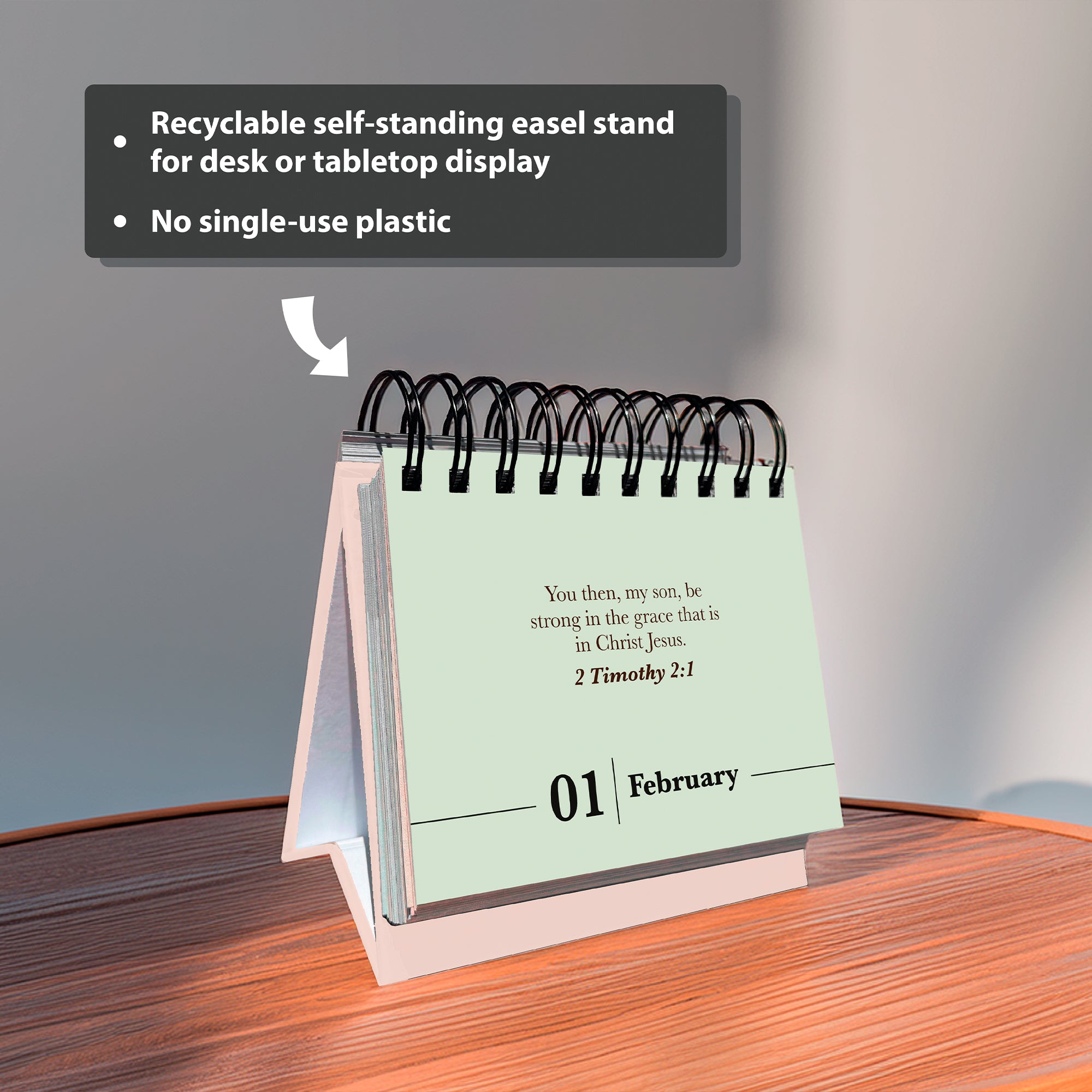 The HannahFaithstore Religious Perpetual Calendar sits spiral-bound on a wooden surface, displaying a Bible verse and date. Its recyclable stand and plastic-free design are also featured.