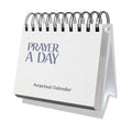 A white spiral-bound "Perpetual Prayer A Day Calendar" by HannahFaithstore is displayed standing on a desk.