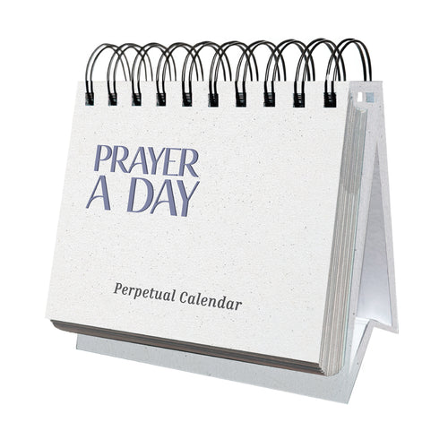 A white spiral-bound "Perpetual Prayer A Day Calendar" by HannahFaithstore is displayed standing on a desk.