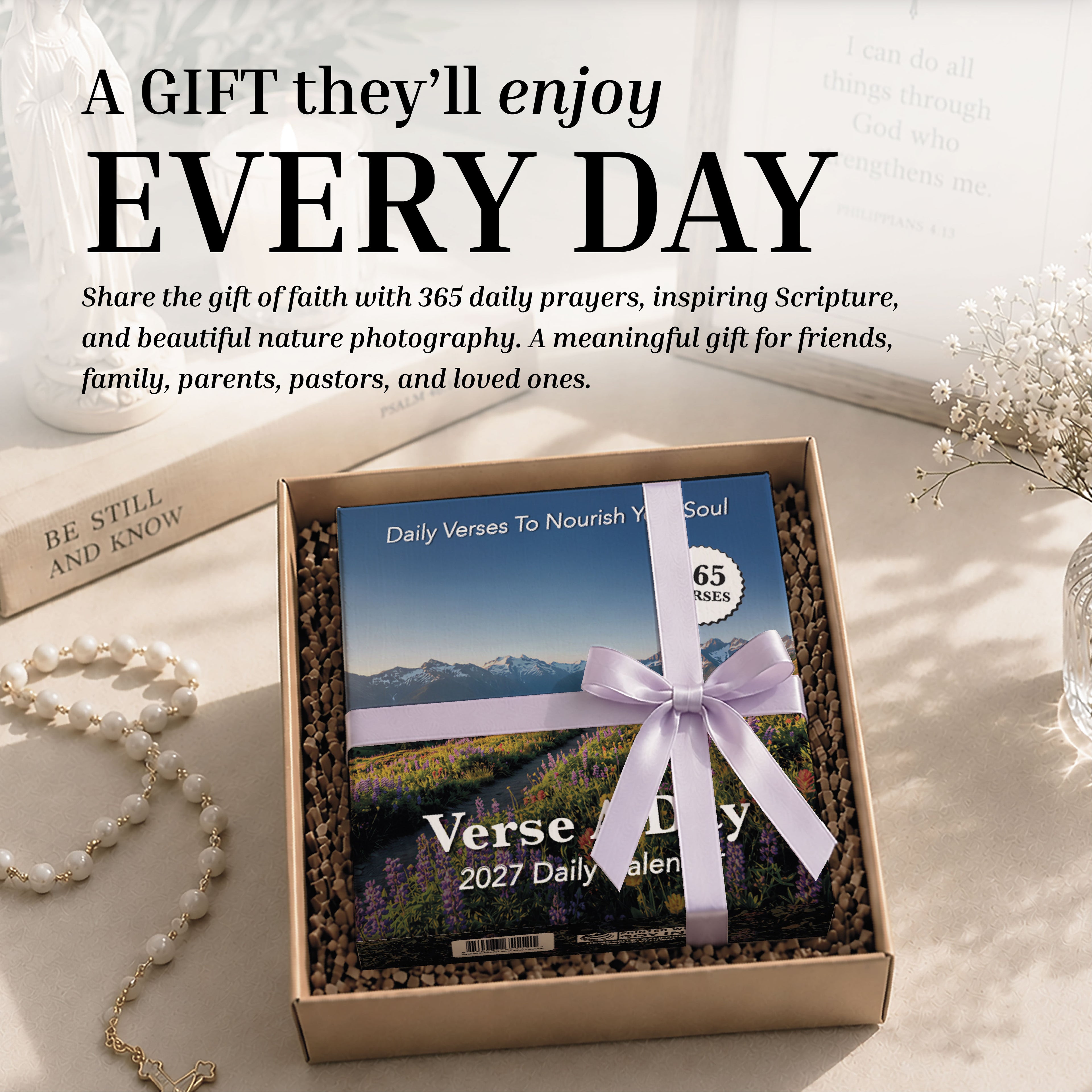 The 2027 A Verse A Day Calendar by HannahFaithstore, elegantly boxed and tied with a lavender ribbon, rests on a table amidst pearls, a ring, and decorative accents—inviting daily inspiration and mindful verses—with promotional text displayed above.